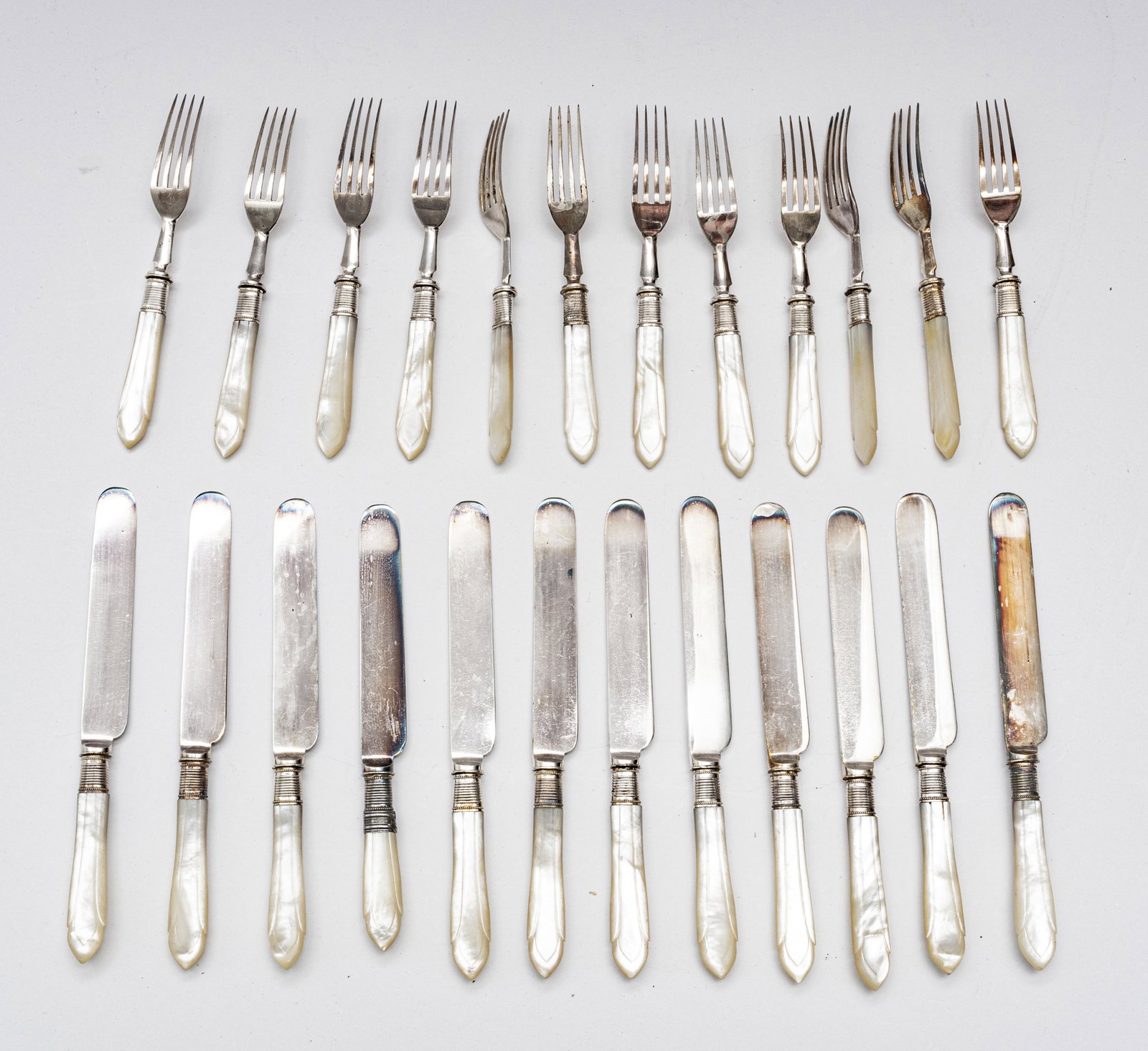 MOTHER OF PEARL & SHEFFIELD DESSERT FORKS, KNIVES: ENGLISH MOTHER OF PEARL AND SHEFFIELD PLATE DESSERT FORKS AND KNIVES, 24 PCS. In fitted box. Handles are well carved mother of pearl.