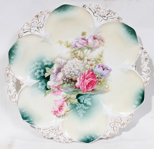 R.S. PRUSSIA CAKE PLATE, C. 1900, DIA 11": R.S. PRUSSIA CAKE PLATE, C. 1900, DIA 11":Porcelain plate with pierced handles and molded floral rim, transferred decorated at the well with pastel flowers; red star mark at the underside.