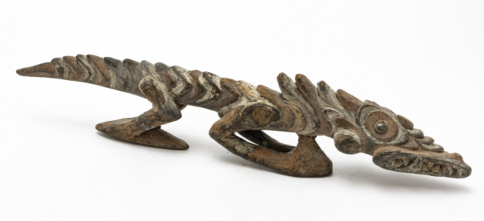 ABORIGINAL CARVED WOOD SCULPTURE OF A LIZARD: ABORIGINAL CARVED WOOD AND PIGMENT SCULPTURE OF A LIZARD, 20TH C., H 5", L 23" Hand-carved wood with natural pigment. Depiction of a spike backed lizard.