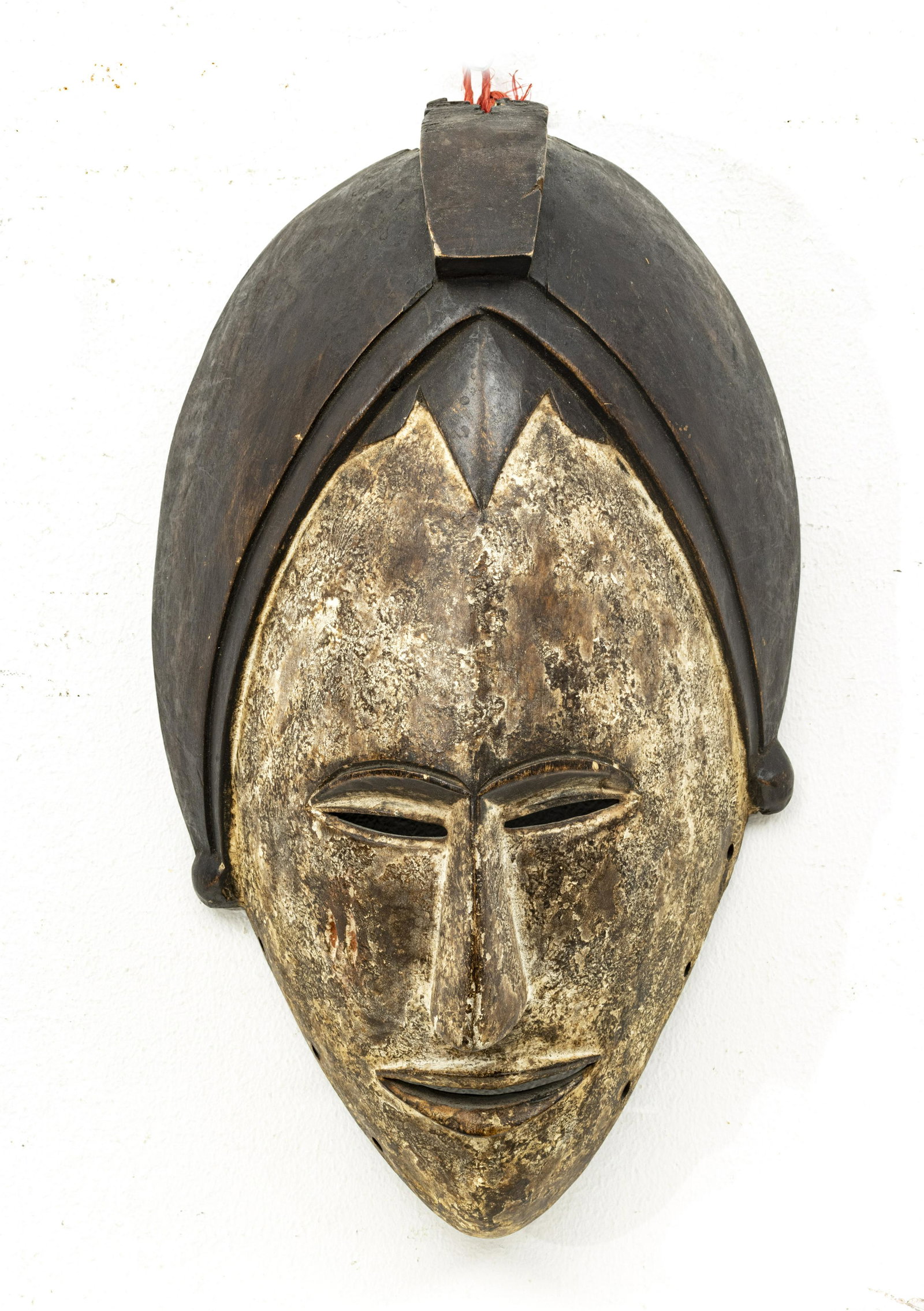 IVORY COAST OVAL WOOD MASK H 15" W 8": IVORY COAST OVAL WOOD MASK H 15" W 8" Slit eyes and mouth. Patinated headpiece. Carved from a single wood specimen. From an Ann Arbor collector.