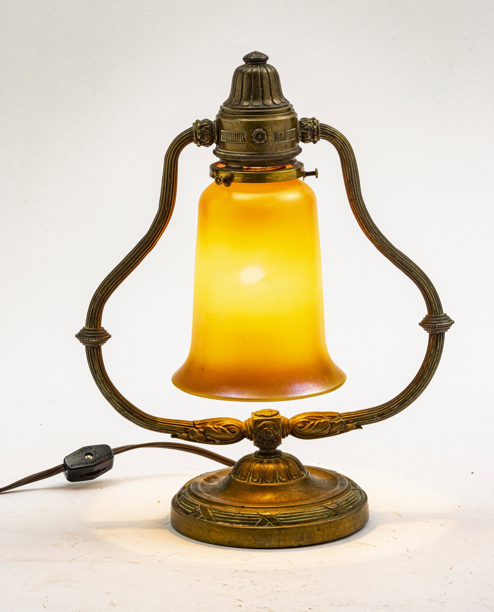 QUEZAL SHADE, BRONZE HARP DESK LAMP: QUEZAL SHADE, BRONZE HARP DESK LAMP, C 1910 H 11.7" W 9.5" Bell form gold luster shade marked Quezal on the interior upper rim.