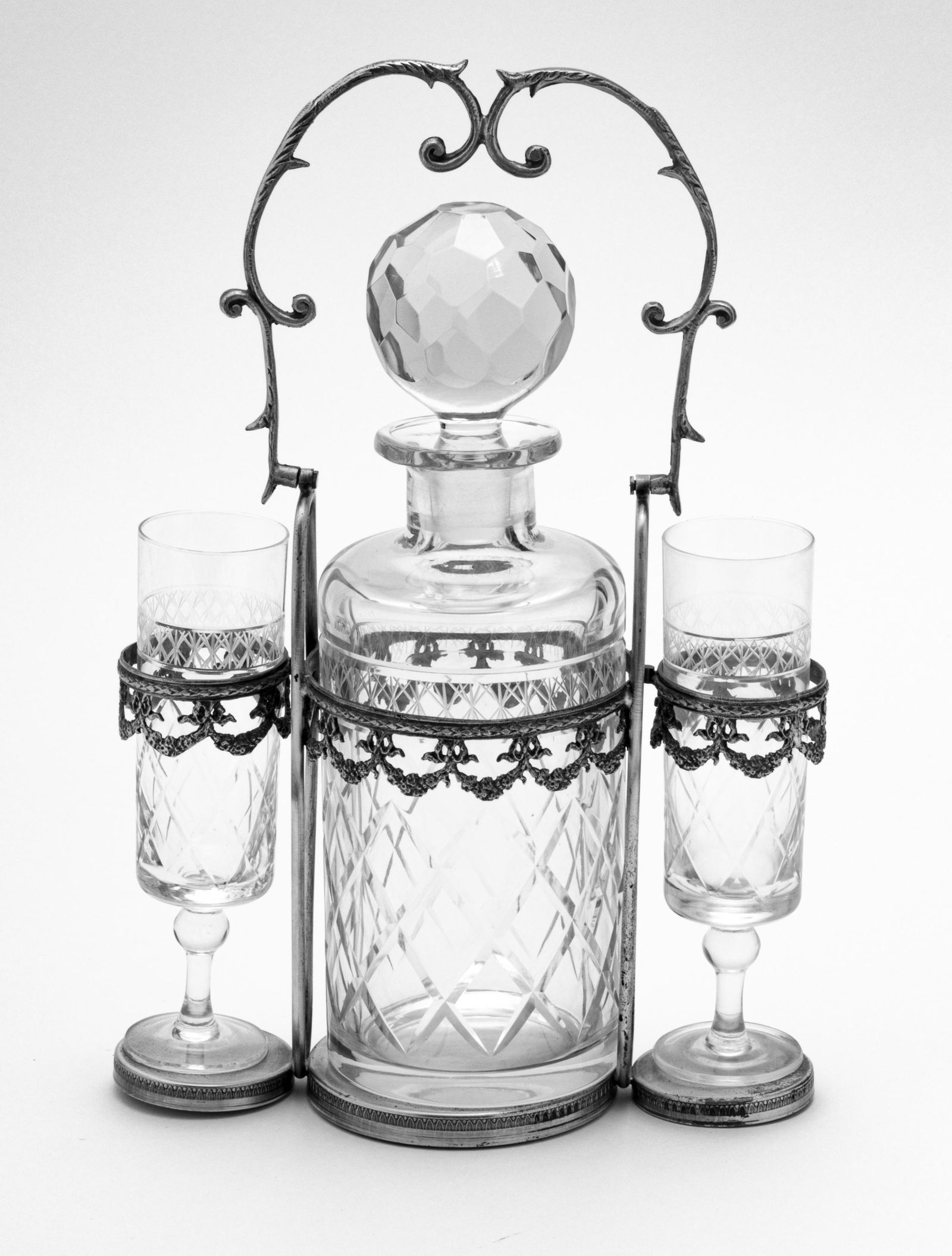 CRYSTAL DECANTER & 2 CHAMPAGNE IN FRAME C 1920: CRYSTAL DECANTER & 2 CHAMPAGNE IN FRAME C 1920 H 13" W 8" Frame holds decanter and two champagne flutes. From the estate of Lois Jacobs, Grosse Pointe Shores.