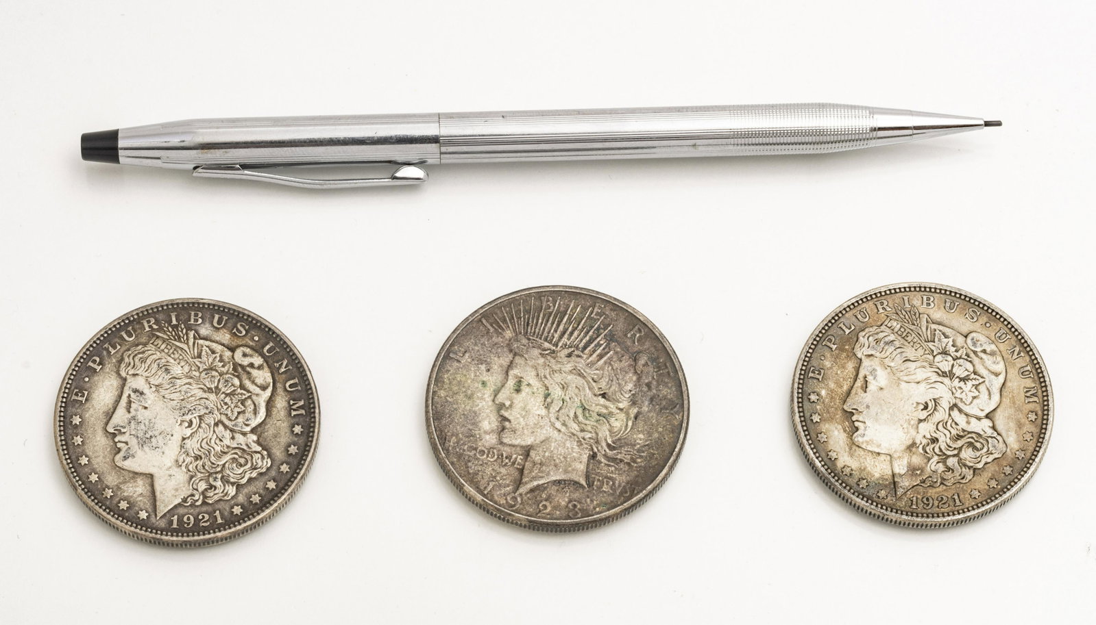 CROSS MECHANICAL PENCIL AND 1921-23 SILVER DOLLARS: CROSS MECHANICAL PENCIL AND 1921-23 SILVER DOLLARS (3) "Century" pencil. Two 1921 silver dollars. One 1923 silver dollar. From the estate of Lois Jacobs, Grosse Pointe Shores.