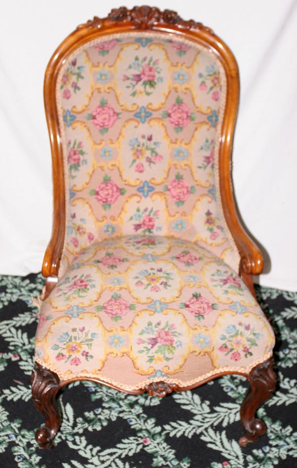 ANTIQUE CARVED WALNUT SLIPPER CHAIR, CIRCA 1870: ANTIQUE CARVED WALNUT SLIPPER CHAIR, CIRCA 1870, H 35", W 23":having original pink rose pattern needlepoint upholstery, carved walnut crest to back frame, below front of seat cushion; carved legs with