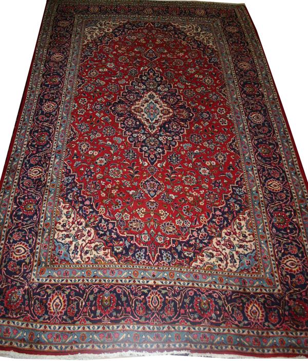 KASHAN PERSIAN RUG, C. 1975, 12' 0" X 8' 0": KASHAN PERSIAN RUG, C. 1975, 12' 0" X 8' 0":Central medallion on a red, ivory and blue ground with overall floral pattern and multiple borders.