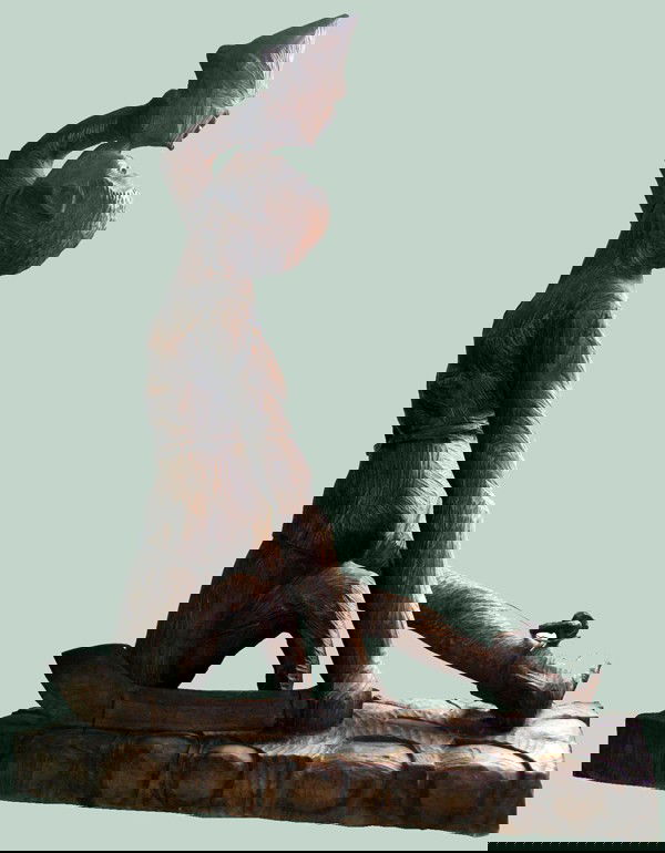 HAITIAN CARVED WOOD FIGURE, H 53", W 14", L 35": HAITIAN CARVED WOOD FIGURE, H 53", W 14", L 35", 'DESSOLINE':Figure depicted is kneeling and is blowing into a conch shell. He has a shackle on his right foot and holds a machete in his left hand.