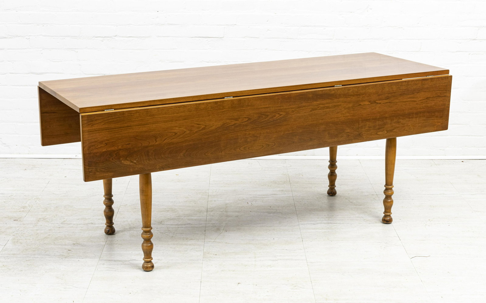 LEOPOLD STICKLEY CHERRY DROPLEAF TABLE: LEOPOLD STICKLEY CHERRY DROPLEAF TABLE, H 29 1/2", W 24", L 72" Bearing a label on the underside that reads "Leopold Stickley Original 1956" (see additional photos). Having two drop leaves, one 11" an