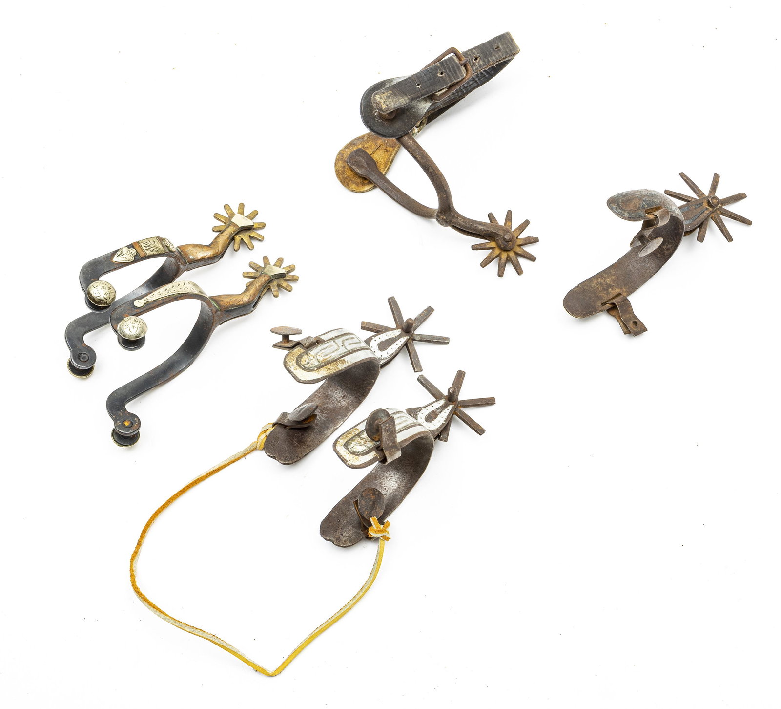 ANTIQUE WESTERN STYLE SPURS, EARLY 20TH C: ANTIQUE WESTERN STYLE SPURS, EARLY 20TH C., SIX PIECES Two pairs, two singles. One pair is designed with spurs in the shapes of legs with floral designs. The second pair having engraved texturing. One