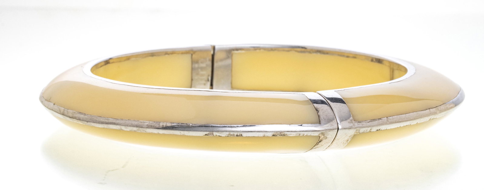 MIRIM SALAT LUCITE & SILVER TONE METAL BRACELET: MIRIM SALAT LUCITE & SILVER TONE METAL BANGLE BRACELET, D 3.5", T.W. 42 GR A Mirim Salat bangle bracelet. Comprised of ivory tone lucite and silver tone metal. Signature branding to the interior band.
