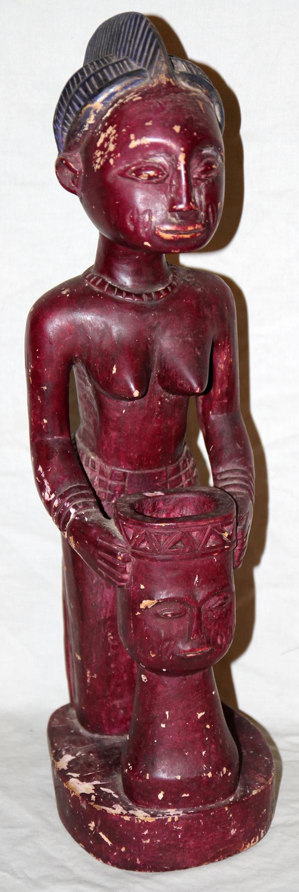 AFRICAN [YORUBA] POLYCHROME/WOOD FEMALE FIGURE: AFRICAN [YORUBA] POLYCHROME & CARVED WOOD KNEELING FEMALE FIGURE, H 24":Featuring a semi-nude female holding a male figured vessel,