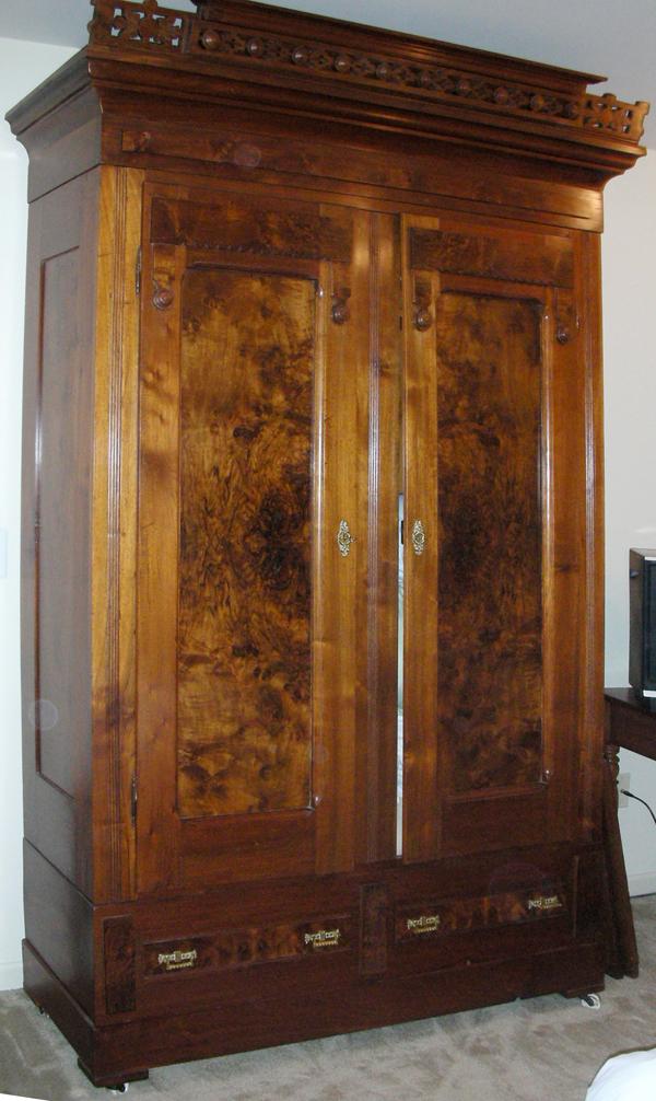 ANTIQUE WALNUT WARDROBE, C. 1890, H 96", W 55": ANTIQUE WALNUT WARDROBE, C. 1890, H 96", W 55", D 18":Armoire having double doors, panel style with figured walnut, overhanging cornice, two drawers at base. From the Estate of Mary Kennedy, Ann Arbor