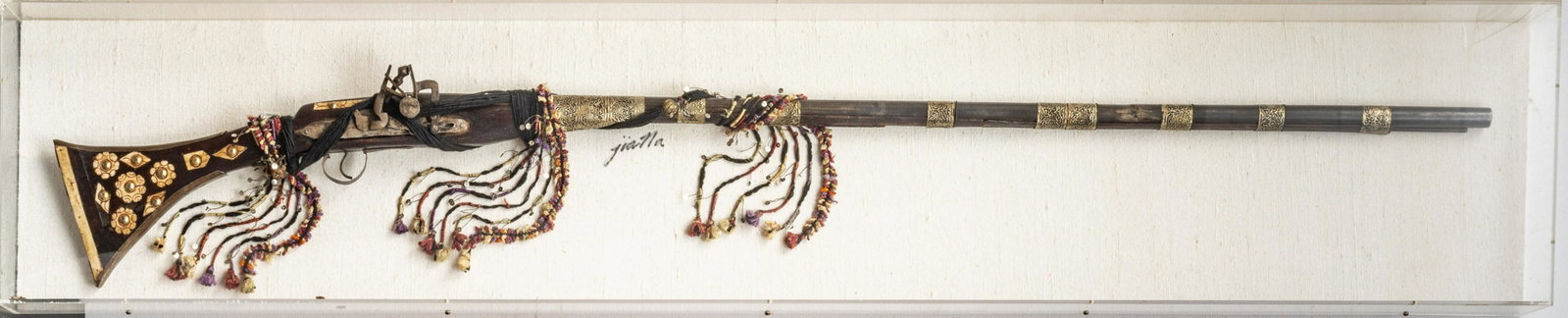 MOROCCAN FLINTLOCK RIFLE, LATE 19TH/EARLY 20TH C., H: MOROCCAN FLINTLOCK RIFLE, LATE 19TH/EARLY 20TH C., H 12.25", W 64.25" Moroccan flintlock rifle presented in a shadowbox frame. Having a bone inlaid stock with hammered silver banding at the barrel. Si