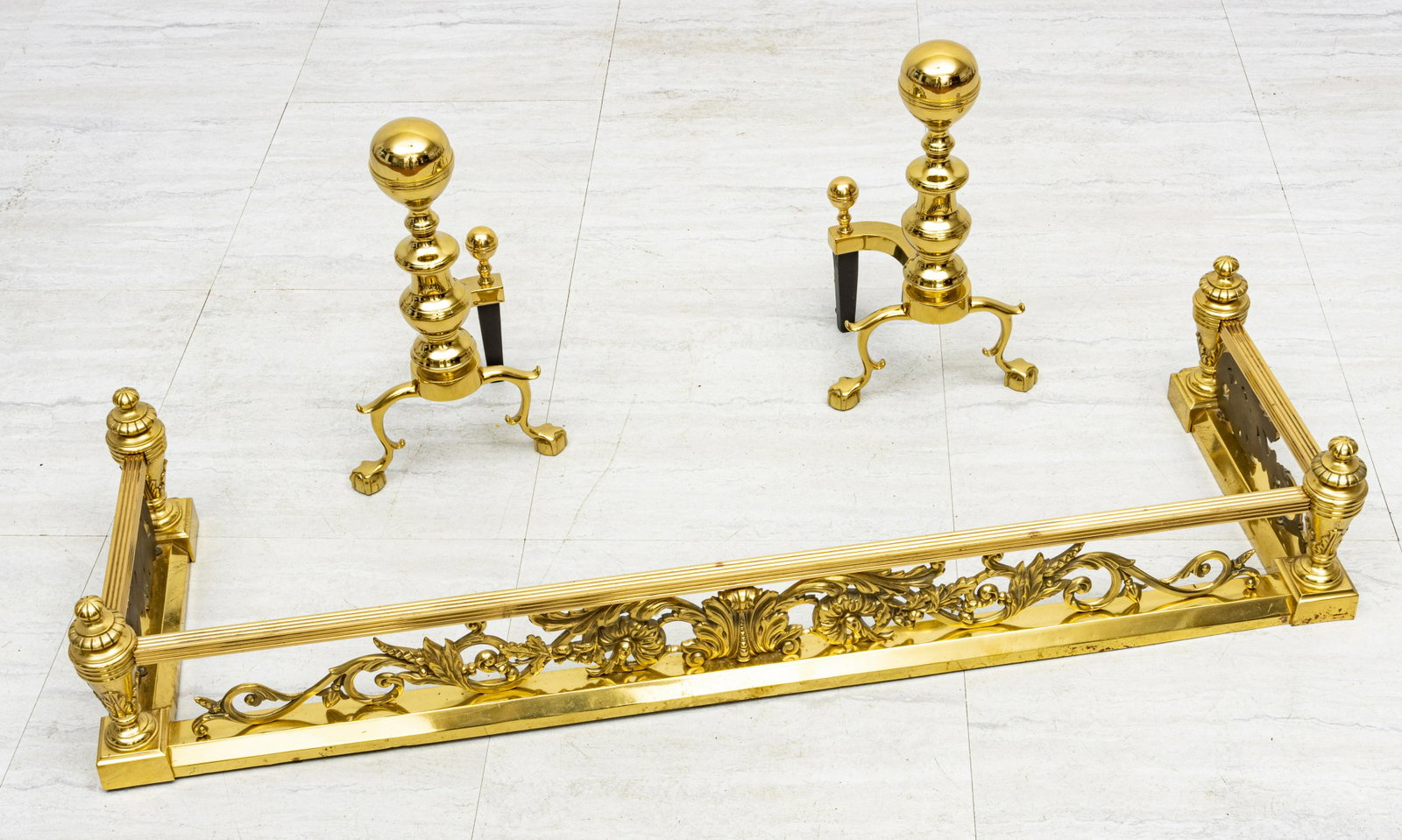 BRASS FIREPLACE FENDER AND ANDIRONS, 20TH C., H 8.5", W: BRASS FIREPLACE FENDER AND ANDIRONS, 20TH C., H 8.5", W 48.5", D 15" (FENDER) Brass fireplace fender having a scrolling vine design. Pair of andirons with ball and claw feet (H 17.5", W 9.5", D 8.5").