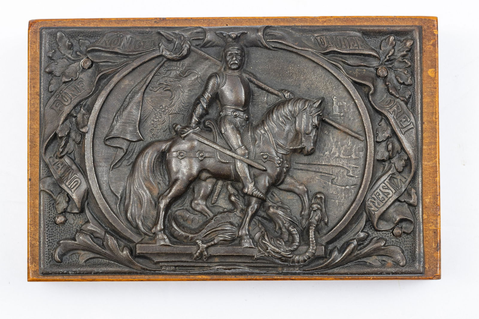 GERMAN BRONZE PLAQUE, WALNUT MOUNT, 19TH C, H 3.5", W: GERMAN BRONZE PLAQUE, WALNUT MOUNT, 19TH C, H 3.5", W 5.25", KAISER ON HORSEBACK A 19th-century German bronze plaque on a walnut mount. Depicting a German emperor on horseback atop a dragon. Banner re