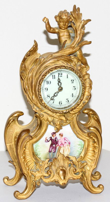 NEW HAVEN CLOCK CO. SPELTER MANTEL CLOCK, H 13": NEW HAVEN CLOCK CO. SPELTER MANTEL CLOCK, H 13", W 7":A gilt metal case with Cupid seated atop, a porcelain panel at the base depicts a courting scene. From the collection of Joseph and Norina Simon,