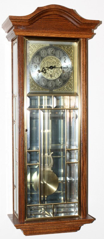ANSONIA OAK & BEVELED GLASS HANGING CLOCK H 34": ANSONIA OAK & BEVELED GLASS HANGING CLOCK, H 34", W 13":Brass pendulum. From the collection of Joseph and Norina Simon, Grosse Pointe Farms, Mi.