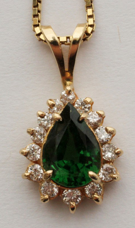 LADY'S GOLD TSAVORITE GARNET & DIAMOND PENDANT: LADY'S 14 KT YELLOW GOLD TSAVORITE GARNET & DIAMOND PENDANT:Pear shaped pendant, 6 x 9 1/2 stone surrounded by eleven .02 1/2 full cut diamonds of 7 clarity and D & E color. 18 kt yellow gold chain. S