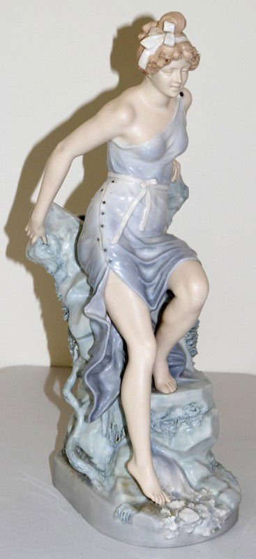 ROYAL DUX PORCELAIN FIGURE OF A SEATED GIRL,: ROYAL DUX PORCELAIN FIGURE OF A SEATED GIRL, H 16", W 6": From the collection of Joseph and Norina Simon, Grosse Pointe Farms, Mi.