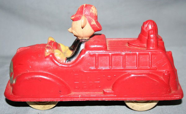 WALT DISNEY PRODUCTIONS MICKEY MOUSE FIRE TRUCK: WALT DISNEY PRODUCTIONS HARD RUBBER MICKEY MOUSE FIRE TRUCK, C1940, L 20":having a red finish with Mickey Mouse driving truck with 'Fire Dept.' on side and the head of Donald Duck at the rear; origina