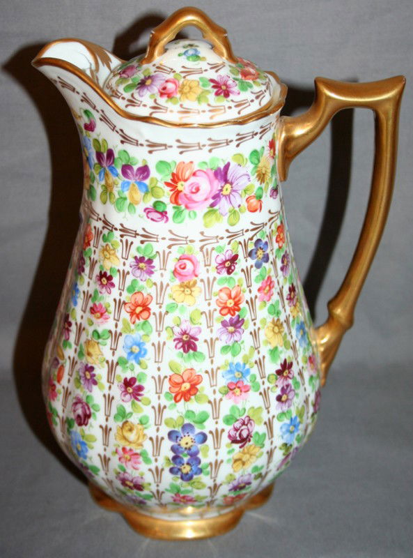 AUSTRIAN PORCELAIN CHOCOLATE POT AND LID, H 9": AUSTRIAN PORCELAIN CHOCOLATE POT AND LID, H 9":having vertical rows of flower blossoms, fired gold trim to handle, rim base and lid; marked: 'Austria' and crown mark with crossed arrows and 'Saxe' on