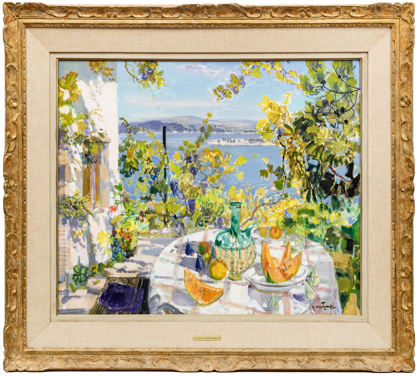 GABRIEL DESCHAMPS, FRENCH B 1919, OIL ON CANVAS, H 25" W 31" COTE D'AZUR: GABRIEL DESCHAMPS, FRENCH B 1919, OIL ON CANVAS, H 25" W 31" COTE D'AZUR Signed lower right. Frame 36" x 40". Summer fruits and bottle of chianti on table with grape vines and water scene in distance.