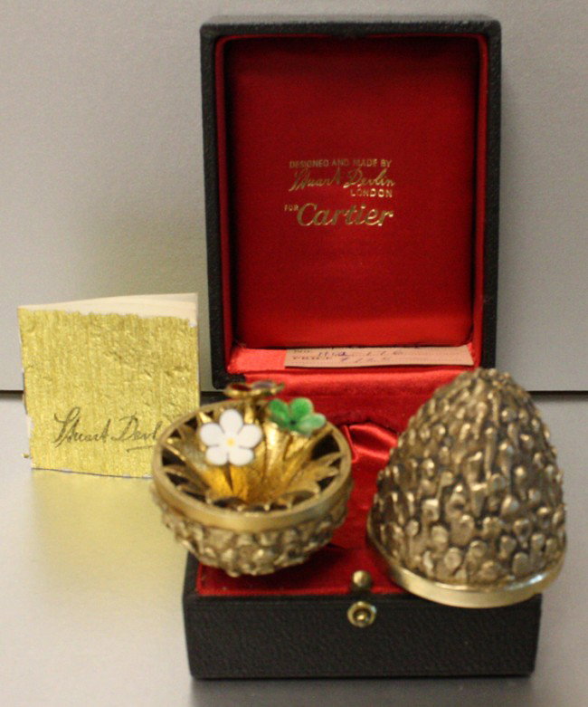 CARTIER STERLING SILVER & VERMEIL COVERED EGG, : CARTIER STERLING SILVER & VERMEIL COVERED EGG, L 2 3/4":Sterling silver egg with gold vermeil, textured exterior. Enamel flowers en Tremblant. Hallmarked '#33 of 300 Limited Edition'. Covered leather 