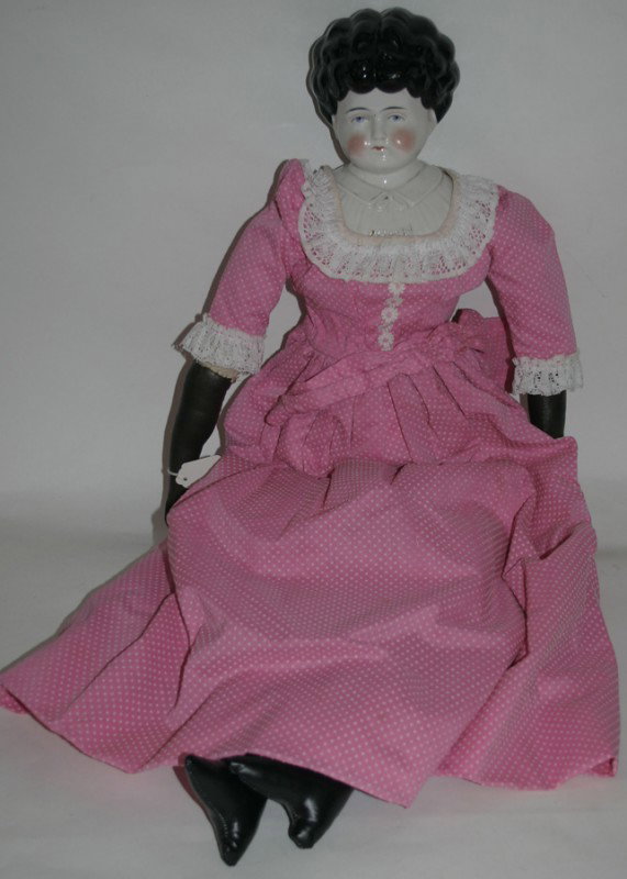 EARLY GERMAN CHINA HEAD DOLL, L 28": EARLY GERMAN CHINA HEAD DOLL, L 28":Leather boots, wearing pink dress. Hair integral part of porcelain head;