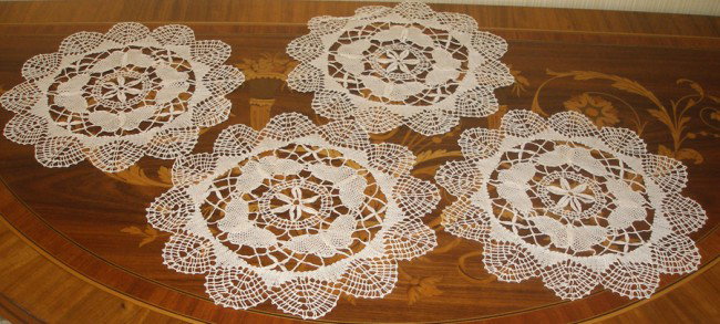 ANTIQUE ECRU DOILIES, SET OF FOUR, DIA 9": ANTIQUE ECRU DOILIES, SET OF FOUR, DIA 9":Hand-crocheted, scalloped edges, central daisy design.