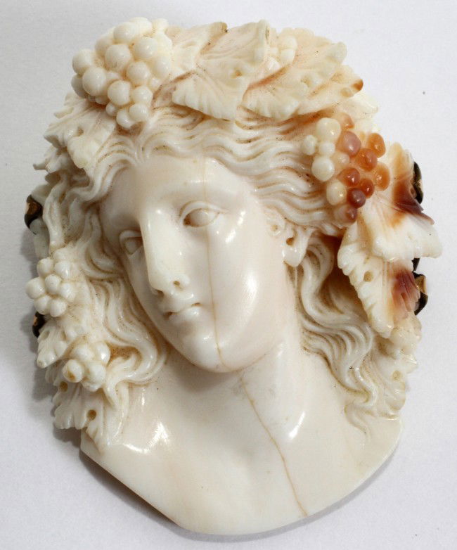 CARVED IVORY BROOCH, EARLY 20TH C., L 1 3/4": CARVED IVORY BROOCH, EARLY 20TH C., L 1 3/4":Classical style female allegory of Autumn wearing a crown of grapes and vines; unmarked backing. From the Estate of Pearl McKenney, Grosse Pointe Farms.