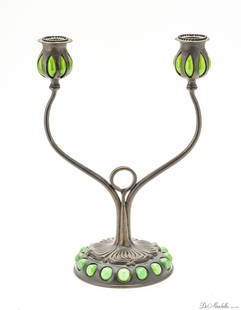 TIFFANY STUDIOS D886 BLOWN OUT DOUBLE CANDLESTICK, BRONZE C. 1905-1915 H 12" W 9": TIFFANY STUDIOS D886 BLOWN OUT DOUBLE CANDLESTICK, BRONZE C. 1905-1915 H 12" W 9" 16 green glass Cabochons around base. Patinated bronze. Loose bobaches, inset glass decoration, base with abstract