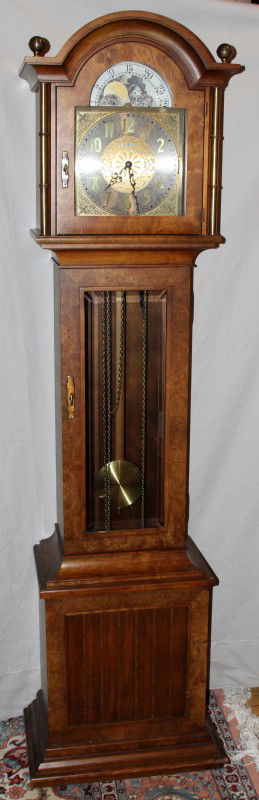 HOWARD MILLER GRANDFATHER CLOCK, H 79", W 20",: HOWARD MILLER GRANDFATHER CLOCK, H 79", W 20", D 14":top having arched moldings with brass finials above a calendar dial, hinged glass door opening to Arabic numeral face; flanked by brass spindles; g