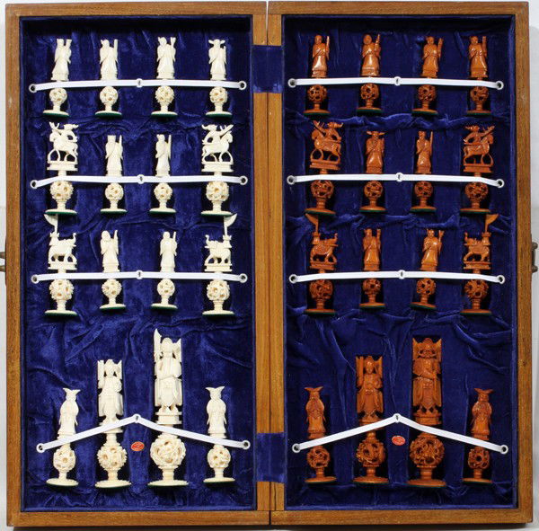 CHINESE CARVED IVORY CHESS SET, 32 PIECES,: CHINESE CARVED IVORY CHESS SET, 32 PIECES, H 6 1/2":All contained within a hinged case/board. The pieces range in height from 3 3/4" - 6 1/2"; each figure stands on a mystery ball base. One group in b
