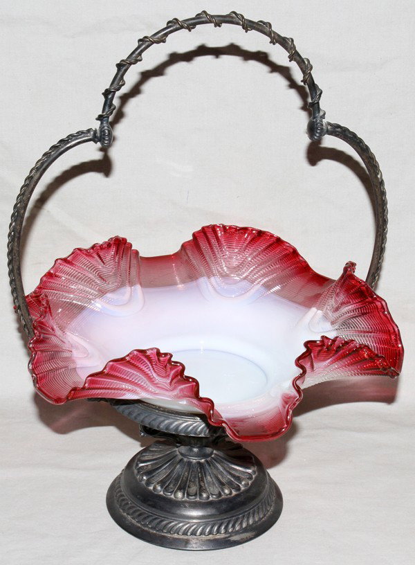 VICTORIAN GLASS BRIDE'S BASKET, C. 1900, H 14": VICTORIAN GLASS BRIDE'S BASKET, C. 1900, H 14", DIA 10":Victorian ruffle edge bride's basket with cranberry edge to opalescent well, silver plate base and wire frame style fixed handle; marked 'Middle