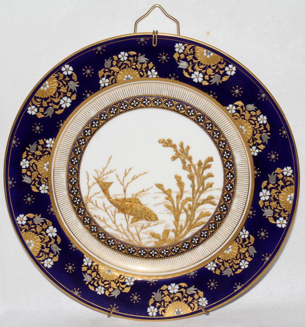 MINTON PORCELAIN PLATE, EARLY 20TH C., DIA 10": MINTON PORCELAIN PLATE, EARLY 20TH C., DIA 10":The well is decorated with a fish swimming among seaweed, within a wide cobalt blue border with gilt and enamel floral sprays.
