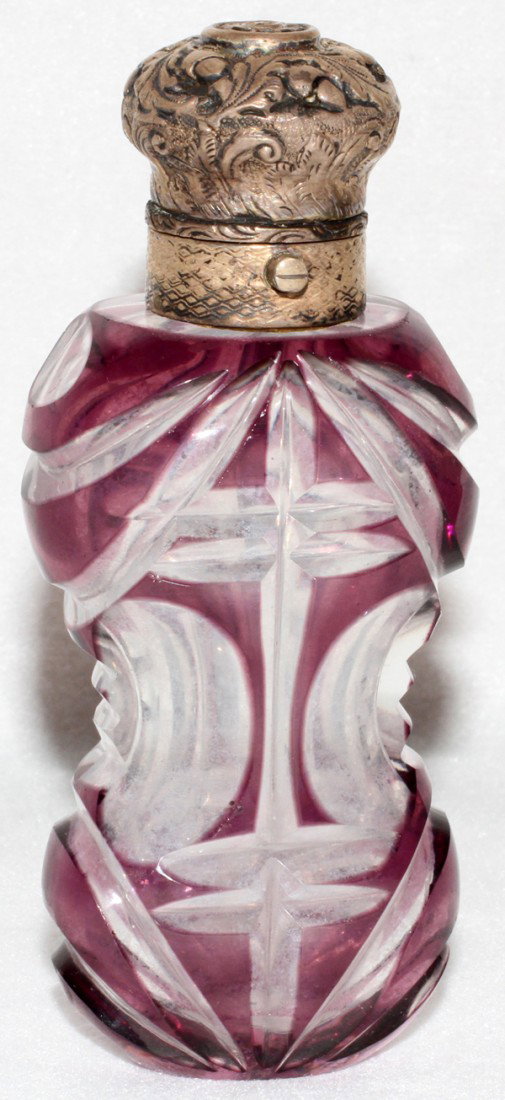 AMETHYST-TO-CLEAR SCENT BOTTLE, LATE 19TH C., : AMETHYST-TO-CLEAR SCENT BOTTLE, LATE 19TH C., L 4":Amethyst overlay cut-to-clear with oval windows and spears; chased silver hinged cap. The Estate of George H. Gowen, Ottawa Hills, Ohio.