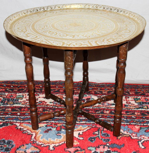 SYRIAN BRASS TRAY ON COLLAPSIBLE STAND, H 19",: SYRIAN BRASS TRAY ON COLLAPSIBLE STAND, H 19", DIA 23 1/2":Heavy gauge tray, hand chased. From the estate of Richard White, Grosse Ile, Mi.