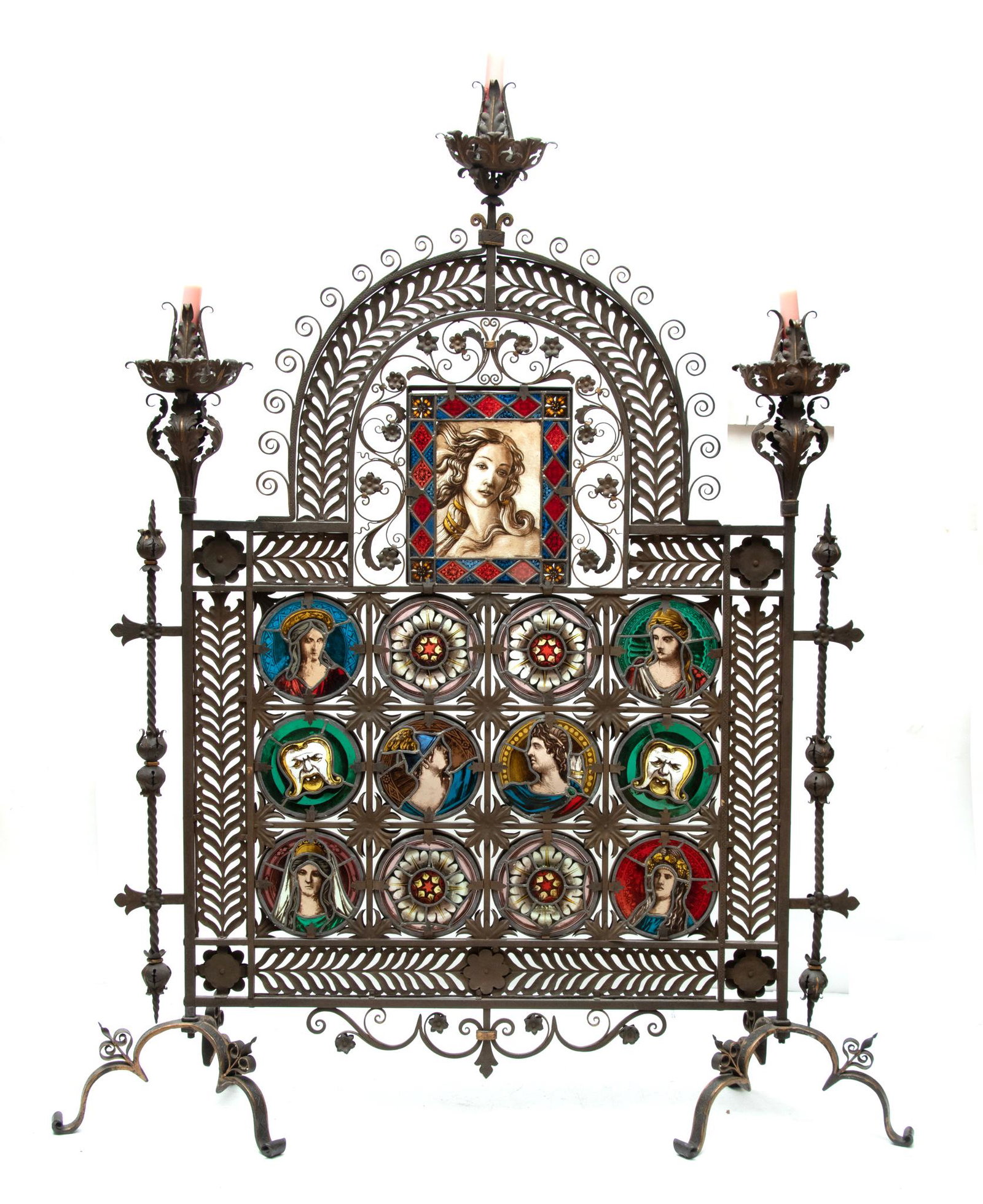 WROUGHT IRON FIREPLACE SCREEN, STAINED AND LEADED GLASS 19TH.C. H 76" W 56": WROUGHT IRON FIREPLACE SCREEN, STAINED AND LEADED GLASS 19TH.C. H 76" W 56" Trestle base with six leg supports. Central stained glass portrait of Venus after Botticelli 9 1/2" x 8", 6 portraits in the