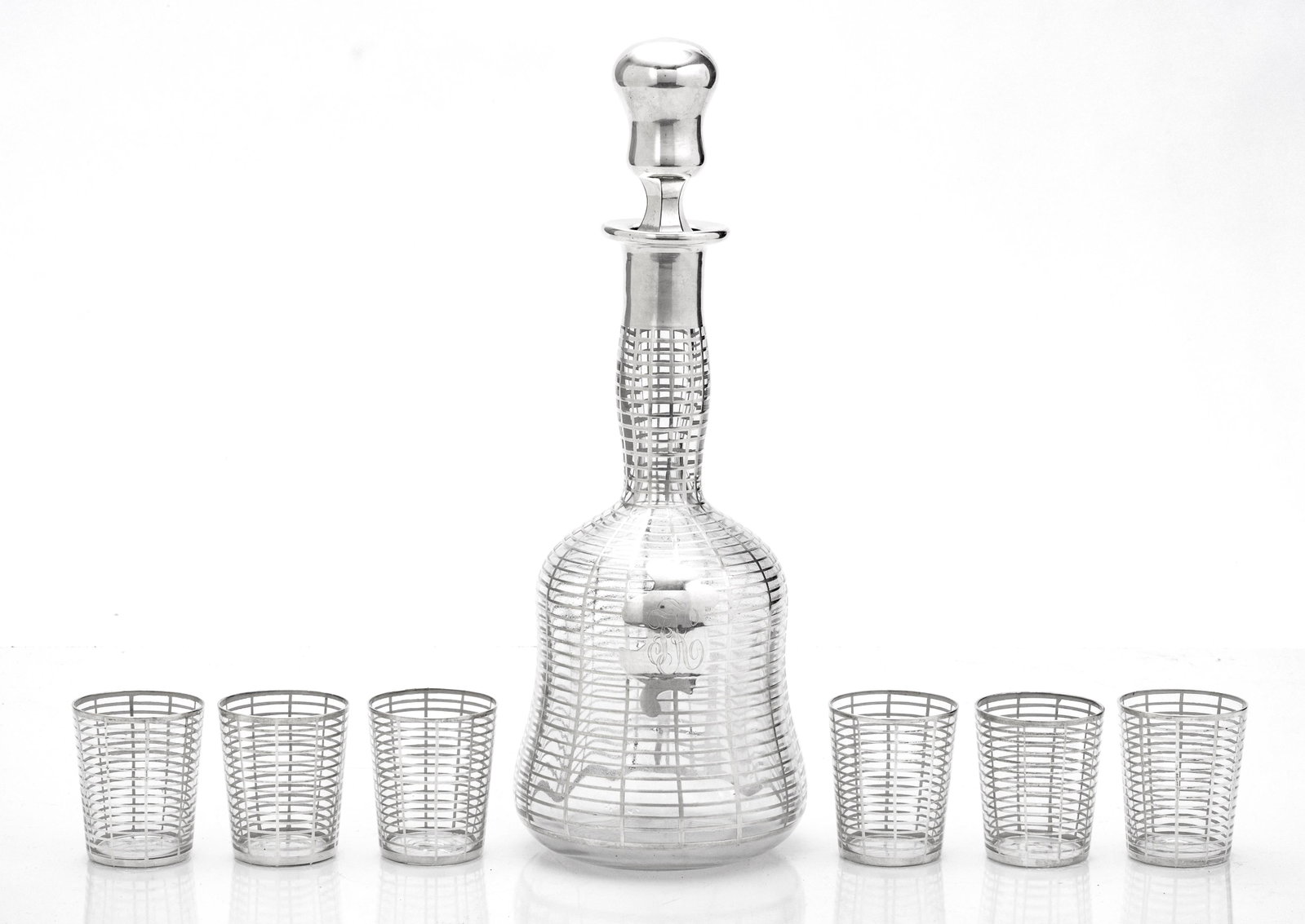 STERLING SILVER OVERLAY ON CRYSTAL DECANTER AND SIX SHOT GLASSES H ": STERLING SILVER OVERLAY ON CRYSTAL DECANTER AND SIX SHOT GLASSES H " Seven piece set. Hand blown crystal decanter with smooth pontil. Unique set circa 1940.
