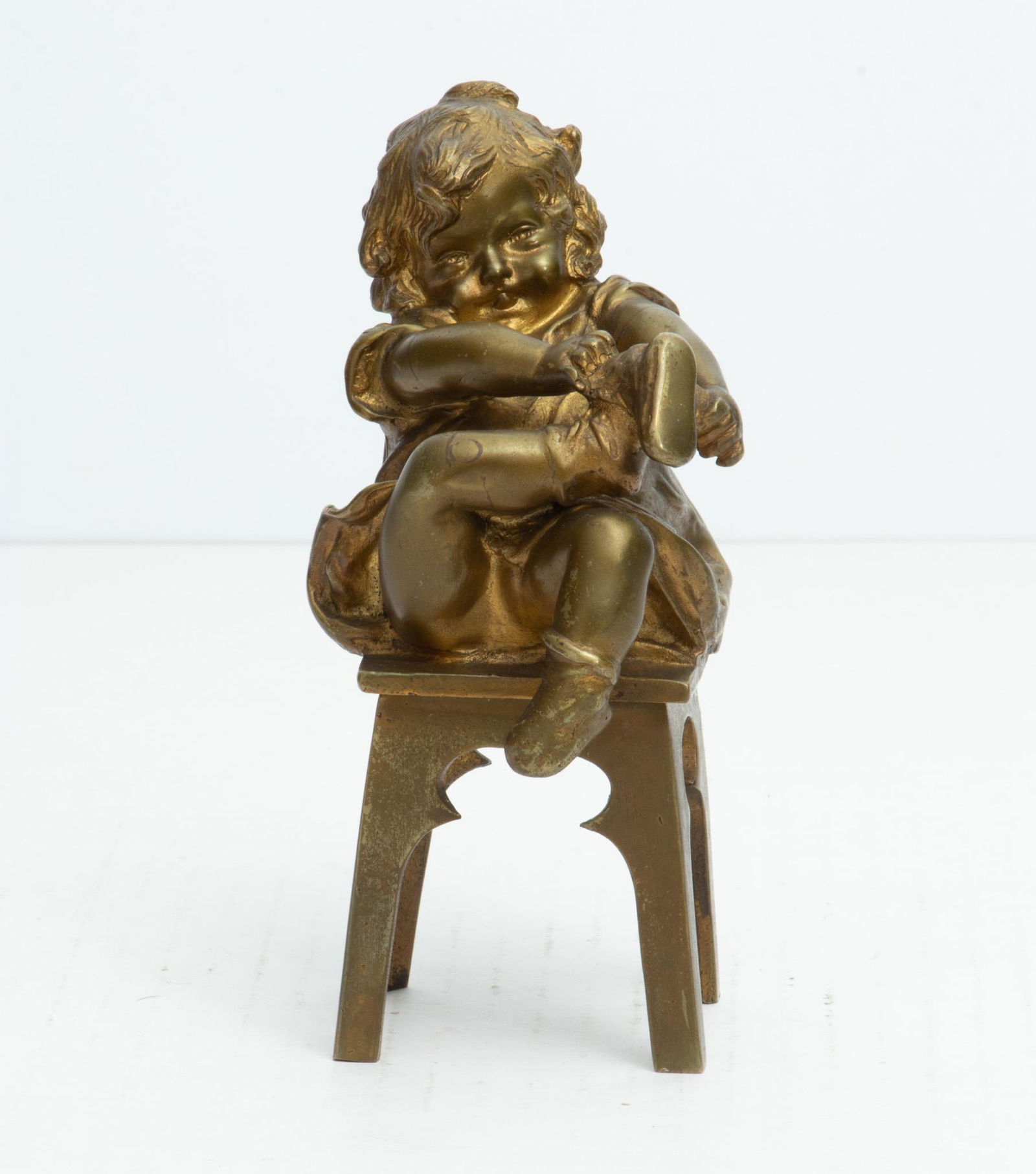 JUAN CLARA, BRONZE, LITTLE GIRL PUTTING ON SHOE, H 6": JUAN CLARA, BRONZE, LITTLE GIRL PUTTING ON SHOE, H 6" Seen putting on shoe. Signed on the side of chair.