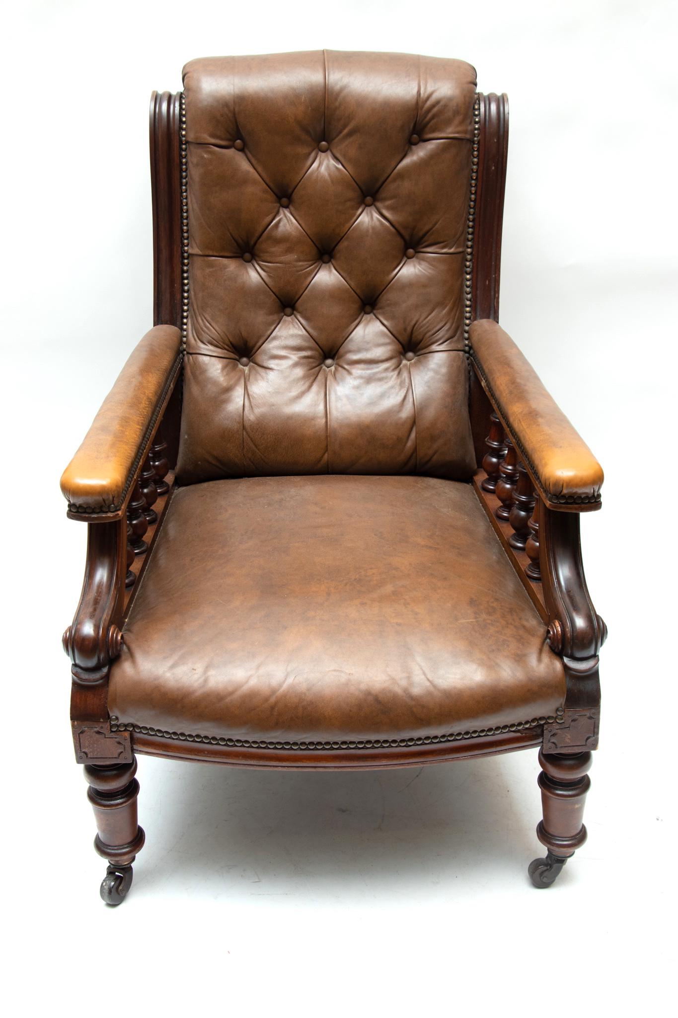 EDWARDIAN STYLE MAHOGANY AND TUFTED BROWN NAUGAHYDE, ARM CHAIR, H 26", W 37": EDWARDIAN STYLE MAHOGANY AND TUFTED BROWN NAUGAHYDE, ARM CHAIR, H 26", W 37" Tufted back. Brass nail-head trim. On castors.