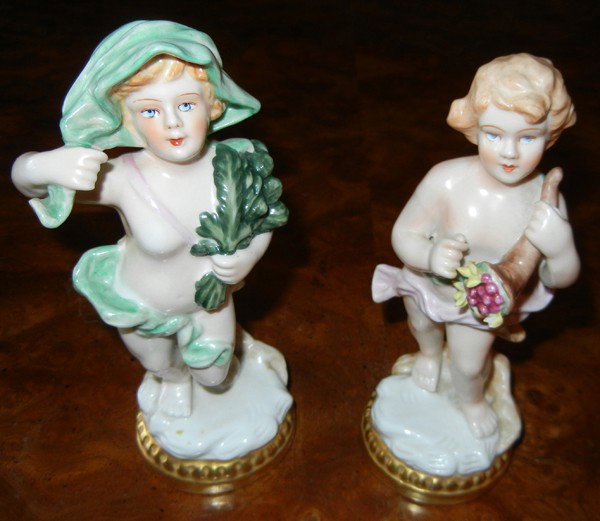 PORCELAIN PORTUGUESE FIGURES, TWO, H 7": PORCELAIN PORTUGUESE FIGURES, TWO, H 7":boy with horn of plenty and girl with acanthus branches; fired gold integral bases;