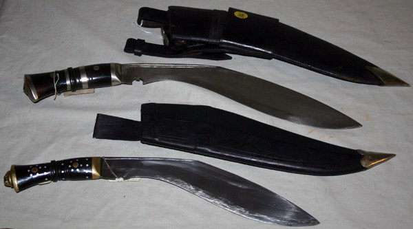 NEPALESE KUKRI KNIVES 2 PCS. L 10" & 12" BLADES: NEPALESE KUKRI KNIVES 2 PCS., L 10" & 12" BLADES:one having a 10" blade with carved hardwood grip and dot inlays brass lion mask pommel, leather over wood sheath (no auxiliary small knives); second Ku
