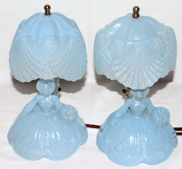 PRESSED GLASS BOUDOIR LAMPS, PAIR, H 5", 9 1/2": PRESSED GLASS BOUDOIR LAMPS, PAIR, H 5", 9 1/2" OVERALL:Pressed glass figural lamp bases are in the image of a Southern Belle with shades have a shell motif. The width of each is 5 1/2".