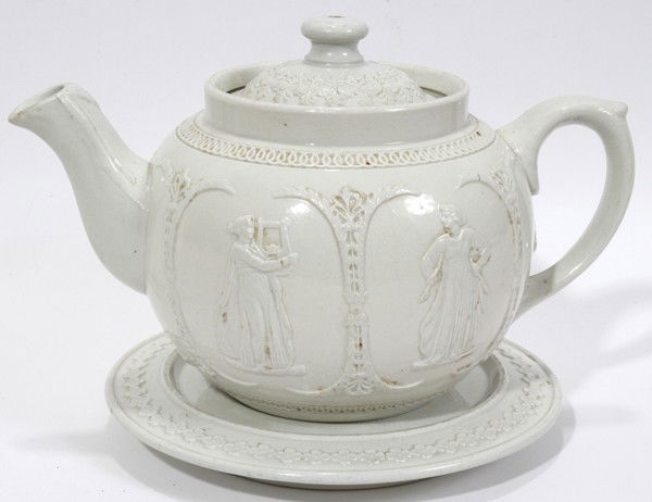 HANLEY, ENGLAND DUDSON BROS. PORCELAIN TEAPOT: HANLEY, ENGLAND DUDSON BROS. PORCELAIN TEAPOT WITH TRIVET, ANTIQUE, H 6", W 7", DIA TRIVET 6":Medallions cameo designs. Hand made white porcelain.