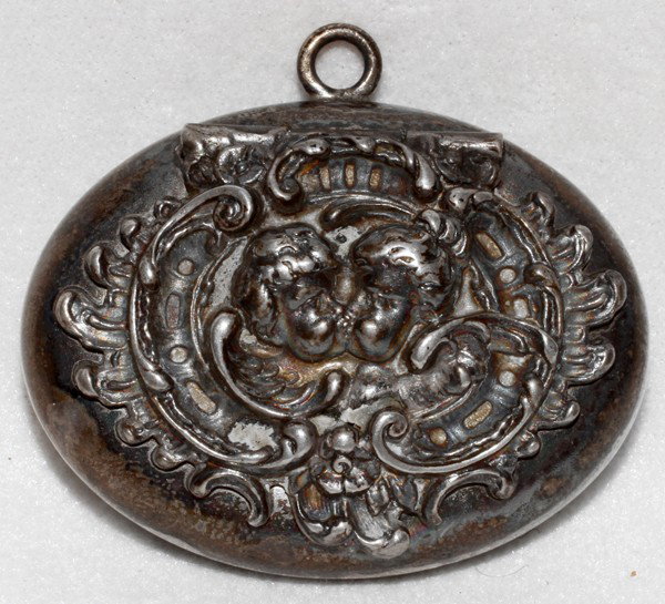 AMERICAN STERLING PILL BOX, C. 1900, L 1 1/3": AMERICAN STERLING PILL BOX, C. 1900, L 1 1/3":Oval shaped sterling silver box with hinged repousse cover of kissing cherubs, engraved monogram on the reverse. The Estate of George H. Gowen, Ottawa Hil