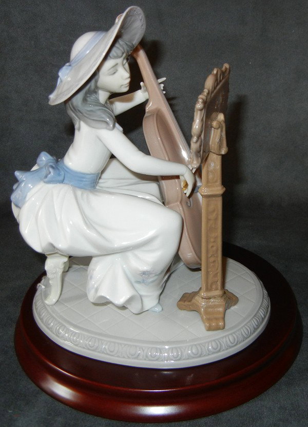 LLADRO PORCELAIN FIGURE 'CONCERTO', H 7 3/4", : LLADRO PORCELAIN FIGURE 'CONCERTO', H 7 3/4", L 6 1/4":Girl seated playing the base, with a music sheet on a stand.