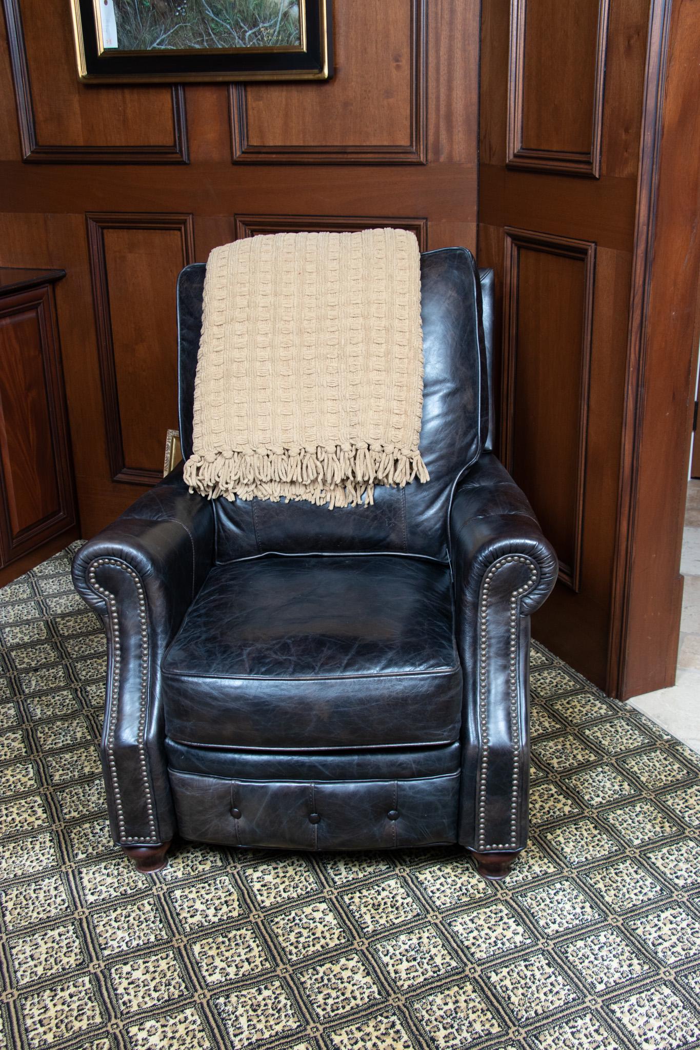 GORMAN LEATHER RECLINER, H 39", W 34", D 36": GORMAN LEATHER RECLINER, H 39", W 34", D 36" Brown leather. Loose seat cushion. Brass nail headsFrom Pebble Beach, Rochester Hills, Mich.
