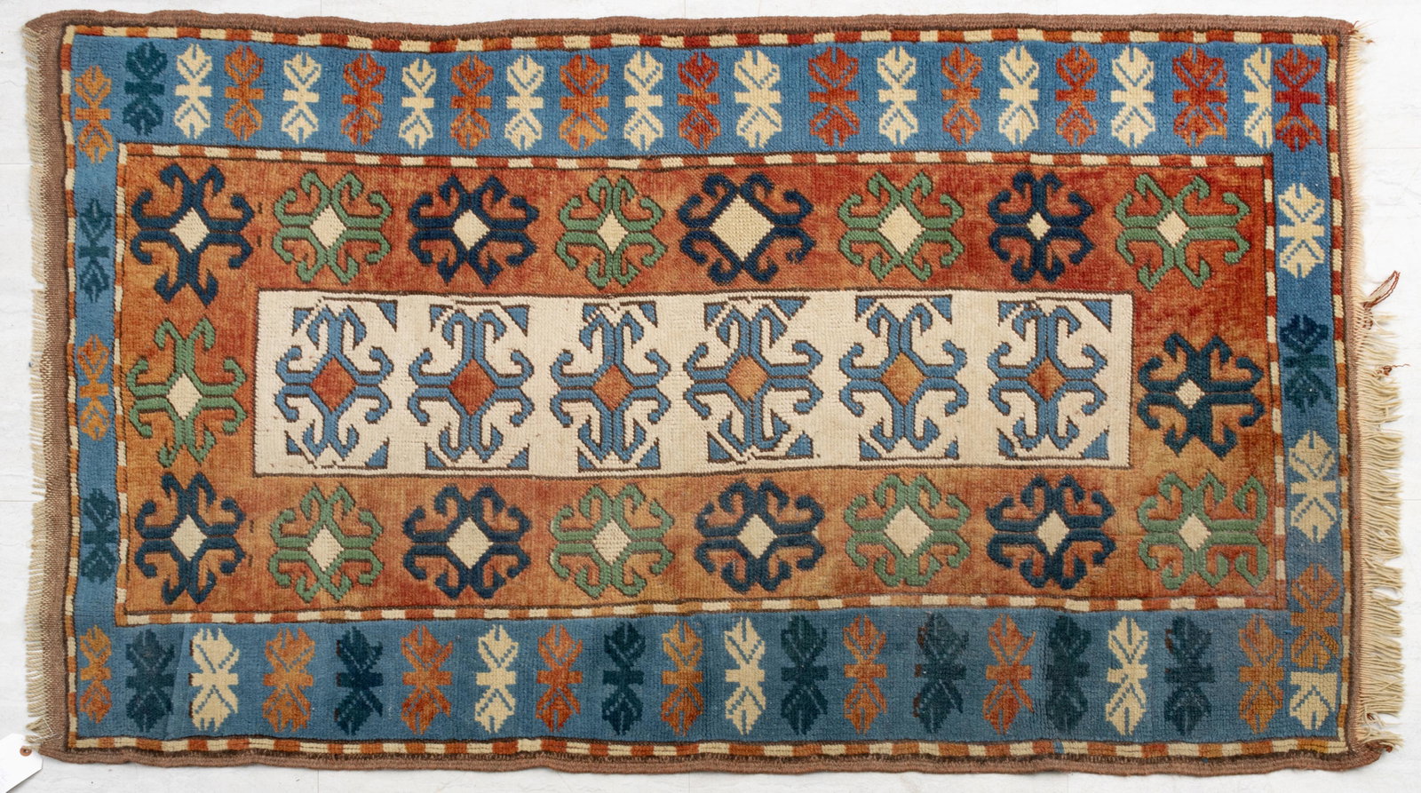 CAUCASIAN HANDWOVEN WOOL RUG, W 3' 4", L 5' 3": CAUCASIAN HANDWOVEN WOOL RUG, W 3' 4", L 5' 3" Ivory central panel with a rust inner border and blue outer border.