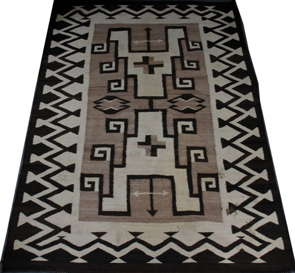 NAVAJO BLANKET, 69" X 49": NAVAJO BLANKET, 69" X 49":Geometric pattern at the center with bisecting arrows at either end; in shades of brown on a cream ground. Black and white zigzag pattern border; Circa 1920-40.