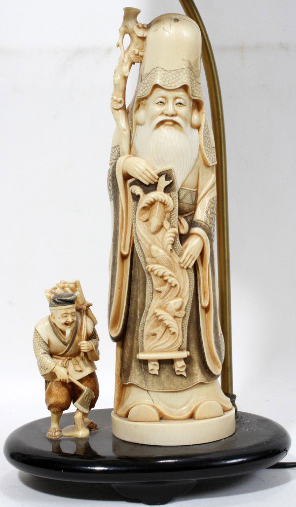 JAPANESE CARVED IVORY FIGURES MOUNTED AS A LAMP: JAPANESE CARVED IVORY FIGURES, H 12", MOUNTED AS A LAMP:Including 1 figure of an aged wise man with domed forehead, holding scroll showing bountiful fish amongst waves, H.12", and 1 figure of a peddle